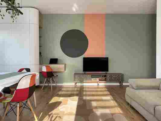 Un apartament din Cluj amenajat cu un perete de accent vopsit în trei culori, cu forme geometrice
